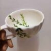 Handbeschilderde keramische latte beker met groen bladpatroon