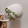Handbeschilderde keramische latte beker met groen bladpatroon