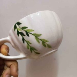 Handbeschilderde keramische latte beker met groen bladpatroon