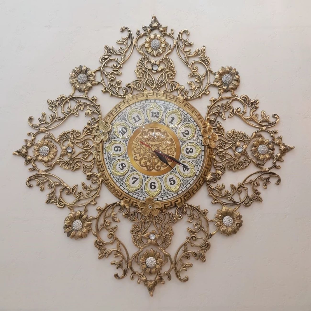 Luxe messing wandklok met fijn bloemmotief
